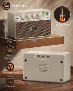 Flatsons FBA-10 mini rechargeable guitar amp in white sitting on a sofa cushion next to a guitar pick and a pair of headphones